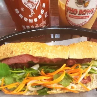 a sandwich with meat, lettuce, and carrots
