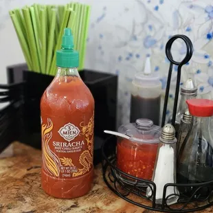 a bottle of hot sauce next to a pair of scissors
