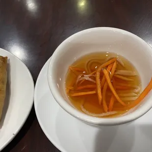 a bowl of soup and a roll