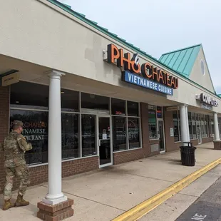 a soldier standing in front of a pharmacy