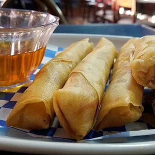 a plate of spring rolls and a cup of tea