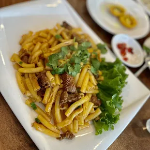 a plate of noodles and meat