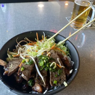 a bowl of food with chopsticks