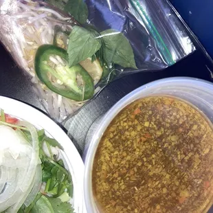 Broth and extra ingredients for shrimp pho bowl.. so generous