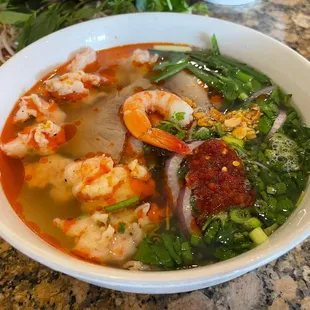 a bowl of soup with shrimp and vegetables