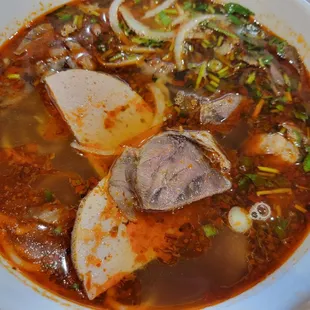 a bowl of soup with meat and vegetables