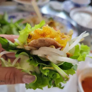 a hand holding a sandwich