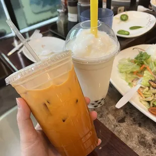 a person holding a plastic cup of iced tea