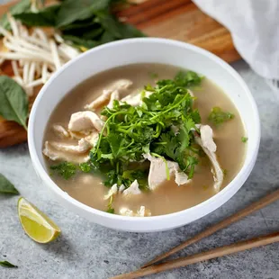 a bowl of soup with chicken and greens