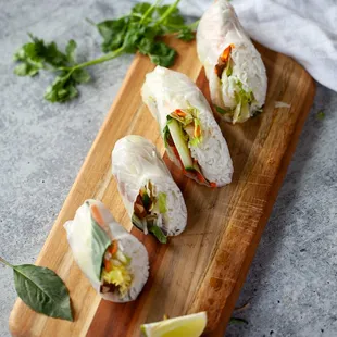 a wooden cutting board with a cut in half sandwich on it