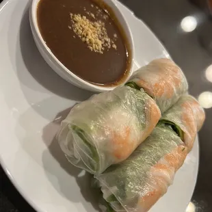 a plate of spring rolls with dipping sauce