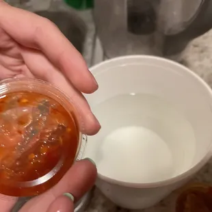 a person holding a cup of soup