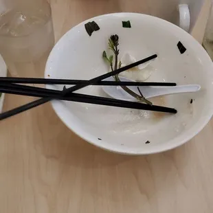 a bowl of noodles and chopsticks