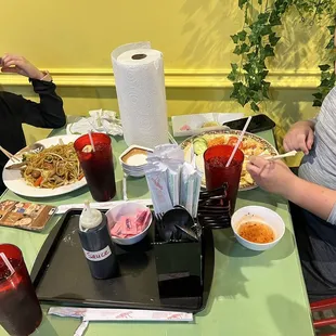 Kids eating lo mein and shrimp and rice plate.