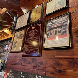 a wall of plaques on a wooden wall