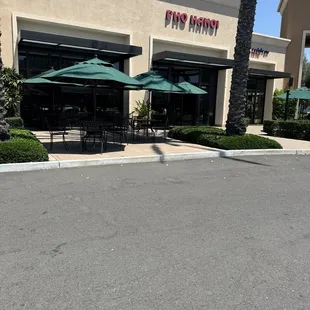 Front of business with outside table seating with umbrellas.   Nice pho soup and restaurant.