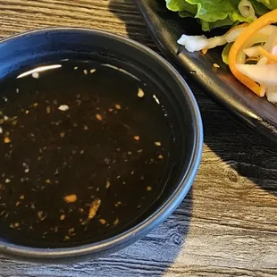 a plate of food and a bowl of dipping sauce