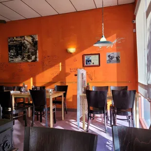 a dining room with orange walls