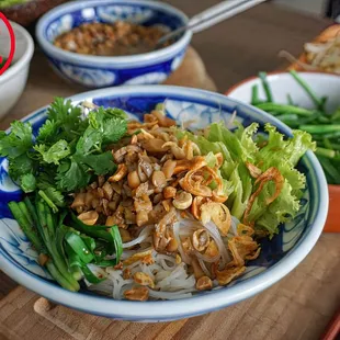 A vegan  dish features rice noodles, tofu, veggies, herbs, and tangy sauce for a fresh, light, and flavorful plant-based meal.