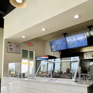 a man standing at the counter of a restaurant