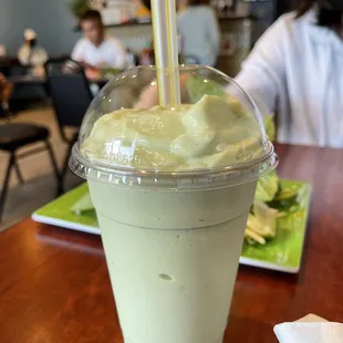 a green smoothie in a plastic cup