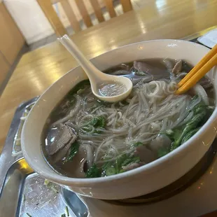 Pho with rare steak and tendon. The broth was standard, and the condiments served on the side.