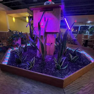 a wooden birdhouse with purple lights
