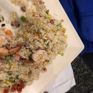a plate of fried rice with shrimp and vegetables