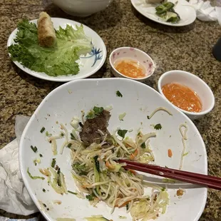 a dirty plate of food with chopsticks