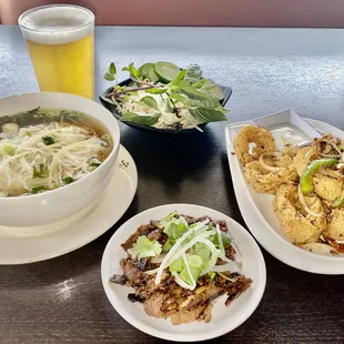 three plates of food and a glass of beer