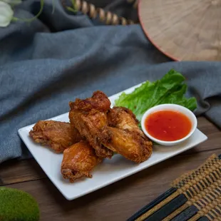 a plate of chicken wings with dipping sauce