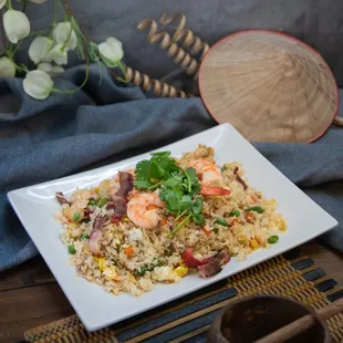 a plate of fried rice with shrimp and vegetables