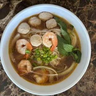 a bowl of soup with shrimp and noodles