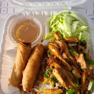 a take out container with a salad and a roll