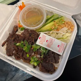 a plastic container with rice, meat and vegetables