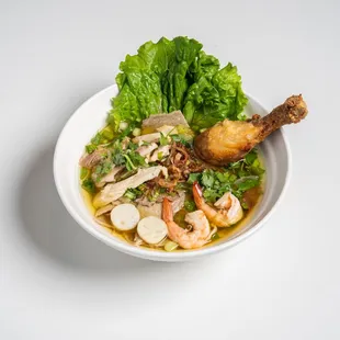 a bowl of soup with shrimp and vegetables