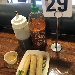 a plate of spring rolls and a bottle of ketchup