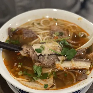 a bowl of soup with meat and noodles