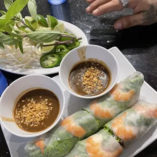 a plate of spring rolls and a bowl of dipping sauce