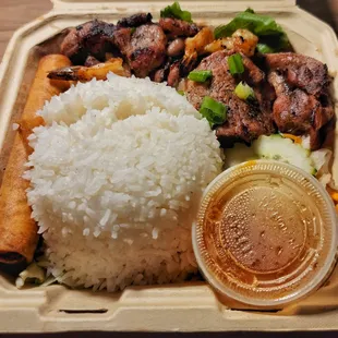a meal of rice, meat, and vegetables in a styrofoam container