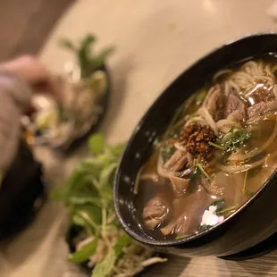 a person holding a spoon over a bowl of soup