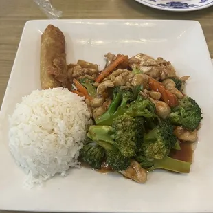 Chicken and broccoli with steamed rice and an egg roll and pork dumplings in the back
