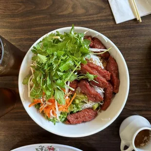 a bowl of meat and vegetables on a table