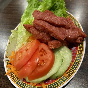Nem Nướng deep-fried strips of marinated ground pork served with pickled carrots &amp; daikon, lettuce, tomato, and cucumber