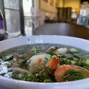 a bowl of soup with shrimp and vegetables