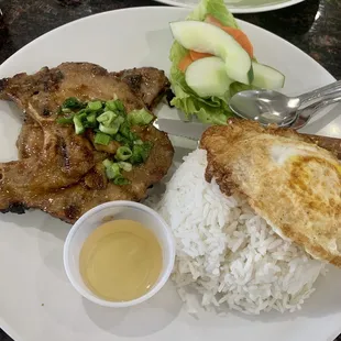 Grilled beef short ribs with rice, cooked egg, fish sauce, and usual fixins with the vegetables.