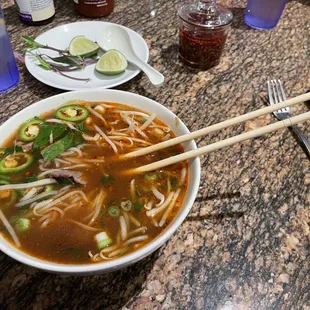 a bowl of soup with chopsticks