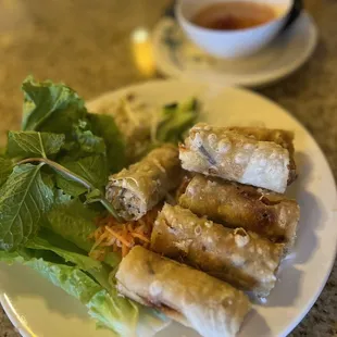 a plate of spring rolls and a salad