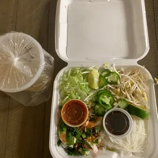 a take out box with a variety of food items