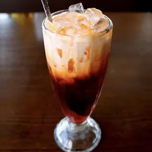 a glass of iced coffee on a table